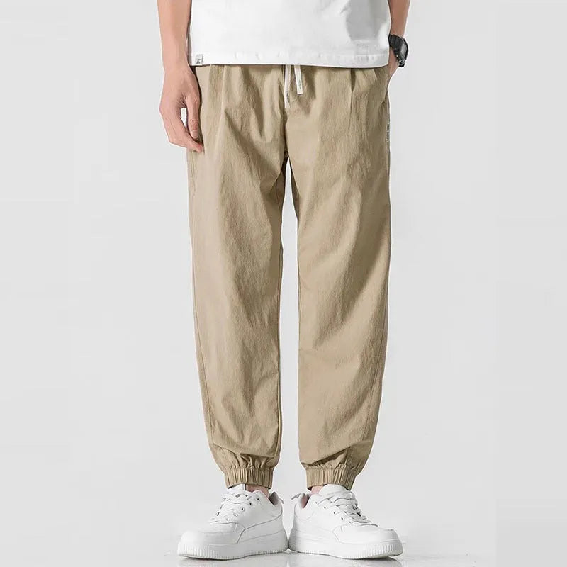 Men's loose cuffed cargo pants in black polyester fabric with cuffed hem and relaxed fit