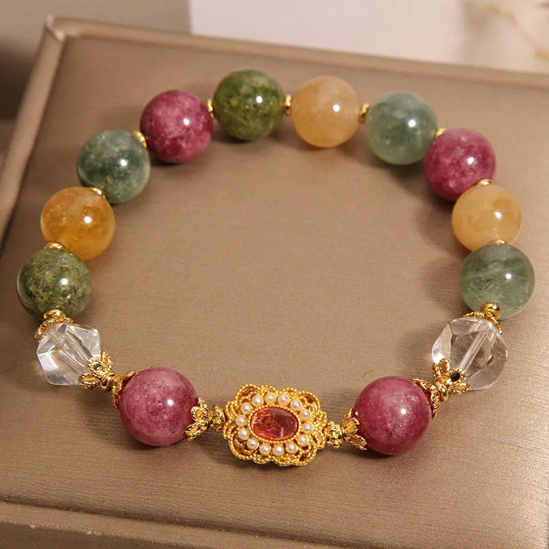 Close-up of a women's bracelet with multicolour tourmaline beads on an alloy band with crystal and rhinestone details.