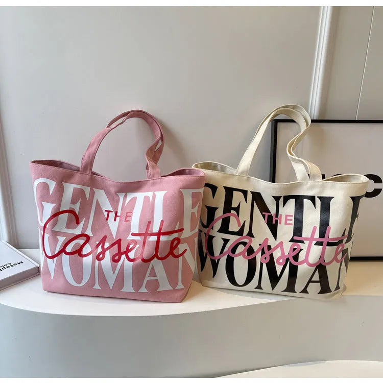 Letter printed canvas tote bag in off white with car stitching detail and top handles