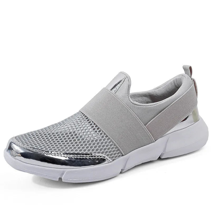 Breathable women's summer sneakers in black, low-tube with mesh inside and PU midsole, side view on hard floor