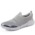 Breathable women's summer sneakers in black, low-tube with mesh inside and PU midsole, side view on hard floor