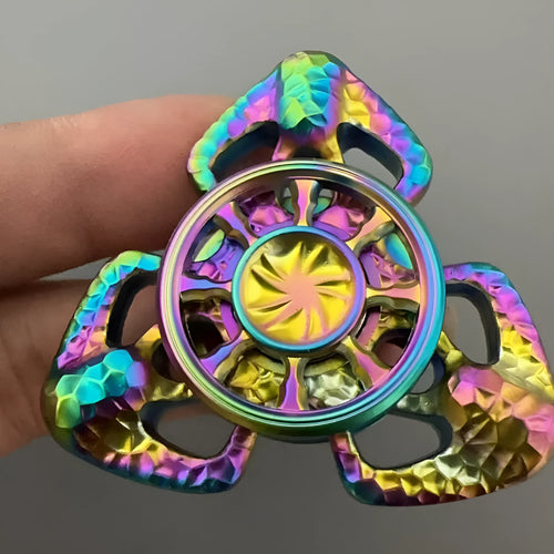 A metal butterfly-shaped fingertip gyro fidget toy spinning on a surface.