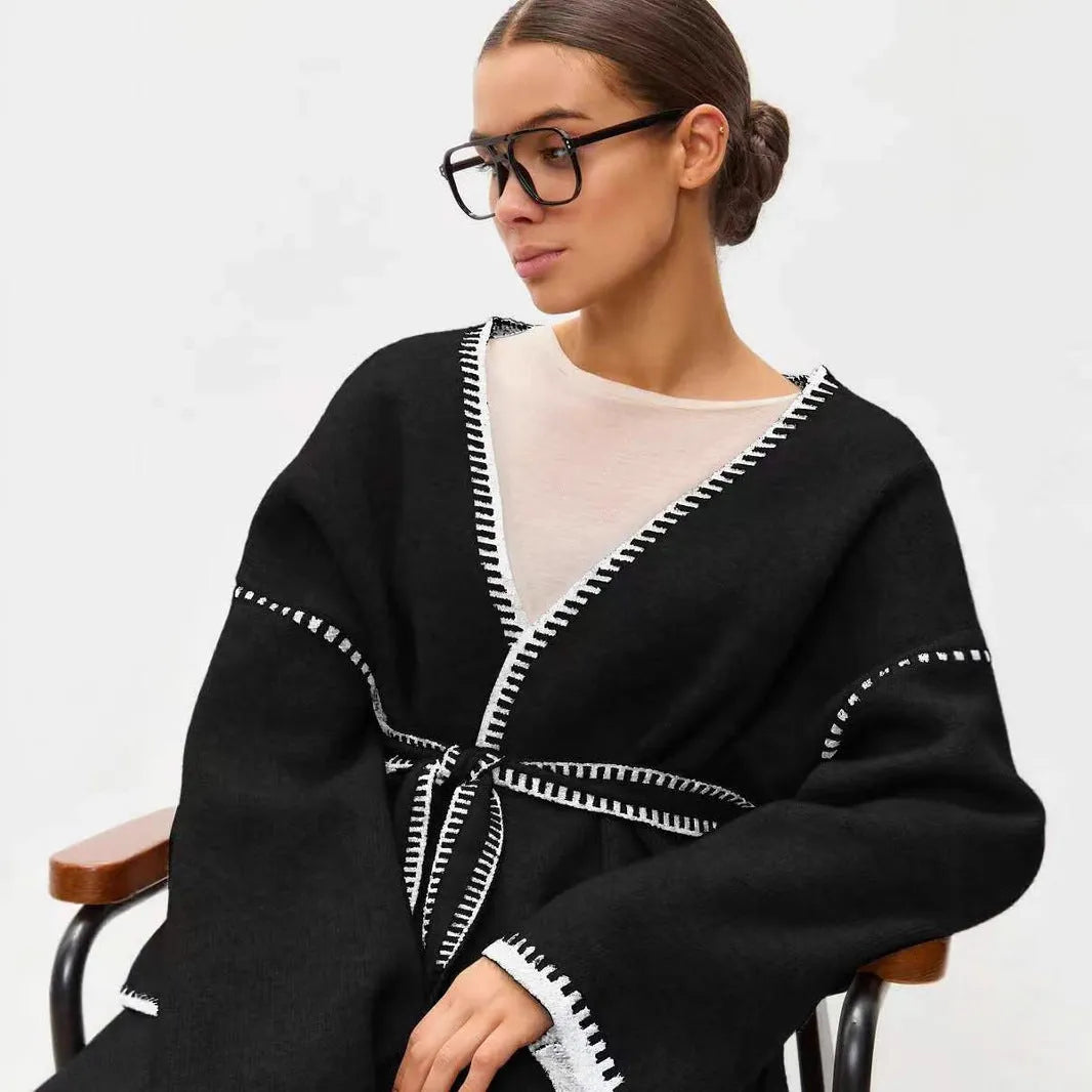 Loose black lace-up knitted cardigan sweater coat with long sleeves.