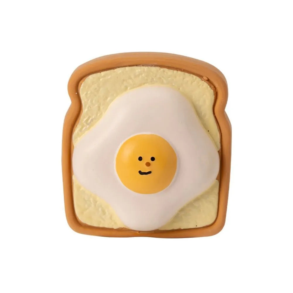 Green and yellow egg-shaped latex dog toy with cartoon bread pattern and squeaker