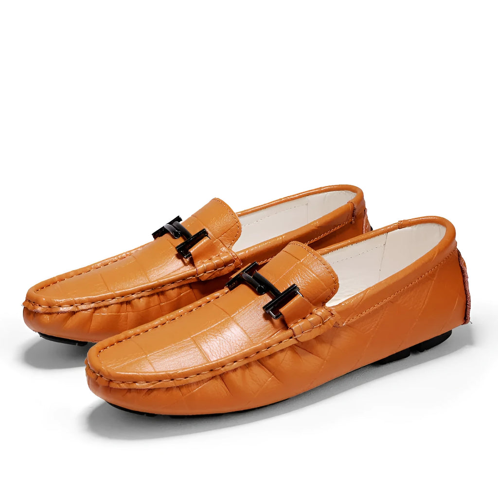 Men's black leather casual shoes with a silver belt buckle closure on a flat rubber sole.