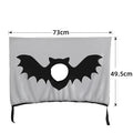 Grey car sun shade curtain with bat pattern and central head hole for dogs, installed on a car window
