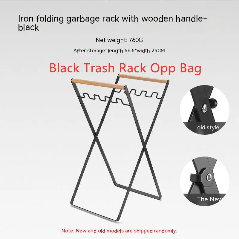 Black iron folding trash storage rack with a wooden handle for hanging bin bags.