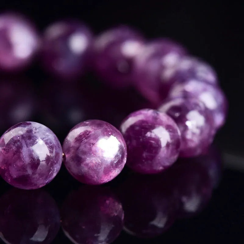 Polished geometric crystal bracelet in purple and pink hues on wrist.