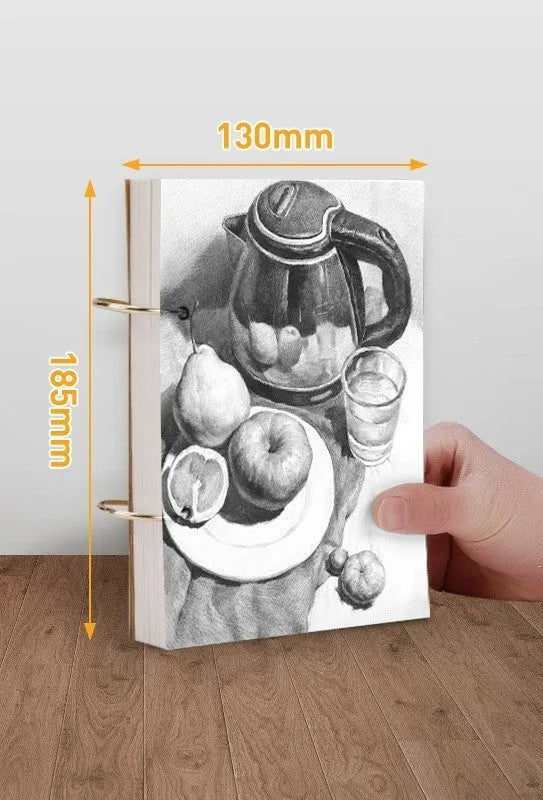 8K thickened sketchbook open on a table with marker drawings, showing linen and black card cover options.