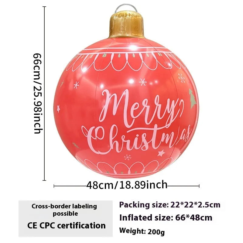 Large red inflatable Christmas ball with flashing lights displayed on a winter garden lawn.