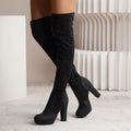 Black suede over-the-knee boots with a high square heel and round toe