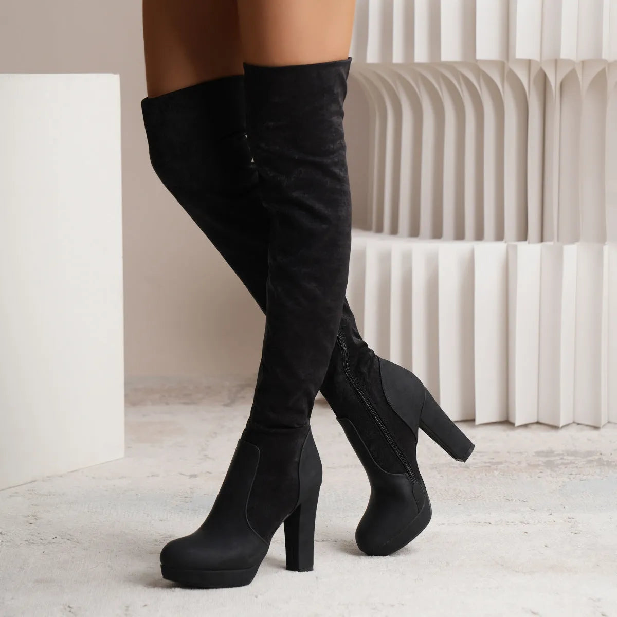Black suede over-the-knee boots with a high square heel and round toe
