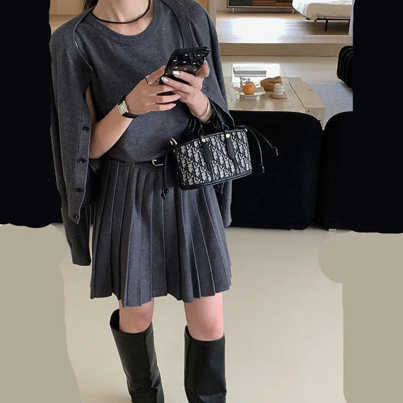 Grey knitted women's two-piece set with a pleated vest skirt and long-sleeved cardigan.