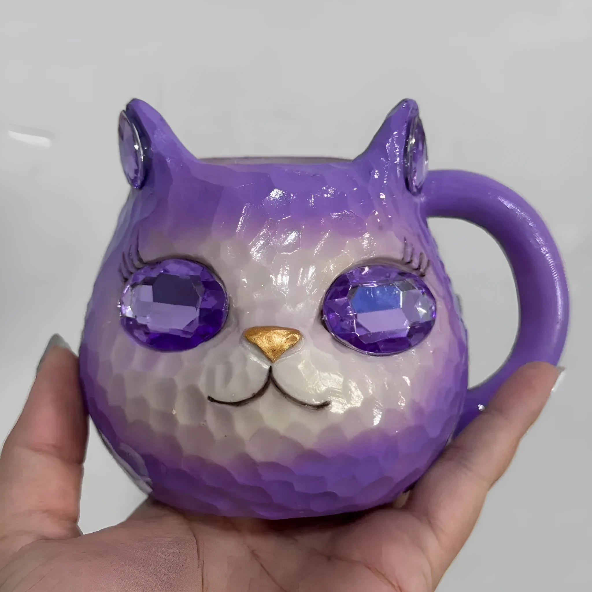 Resin cat cup crystal globe decorative ornament on a desk, shown in purple colour.