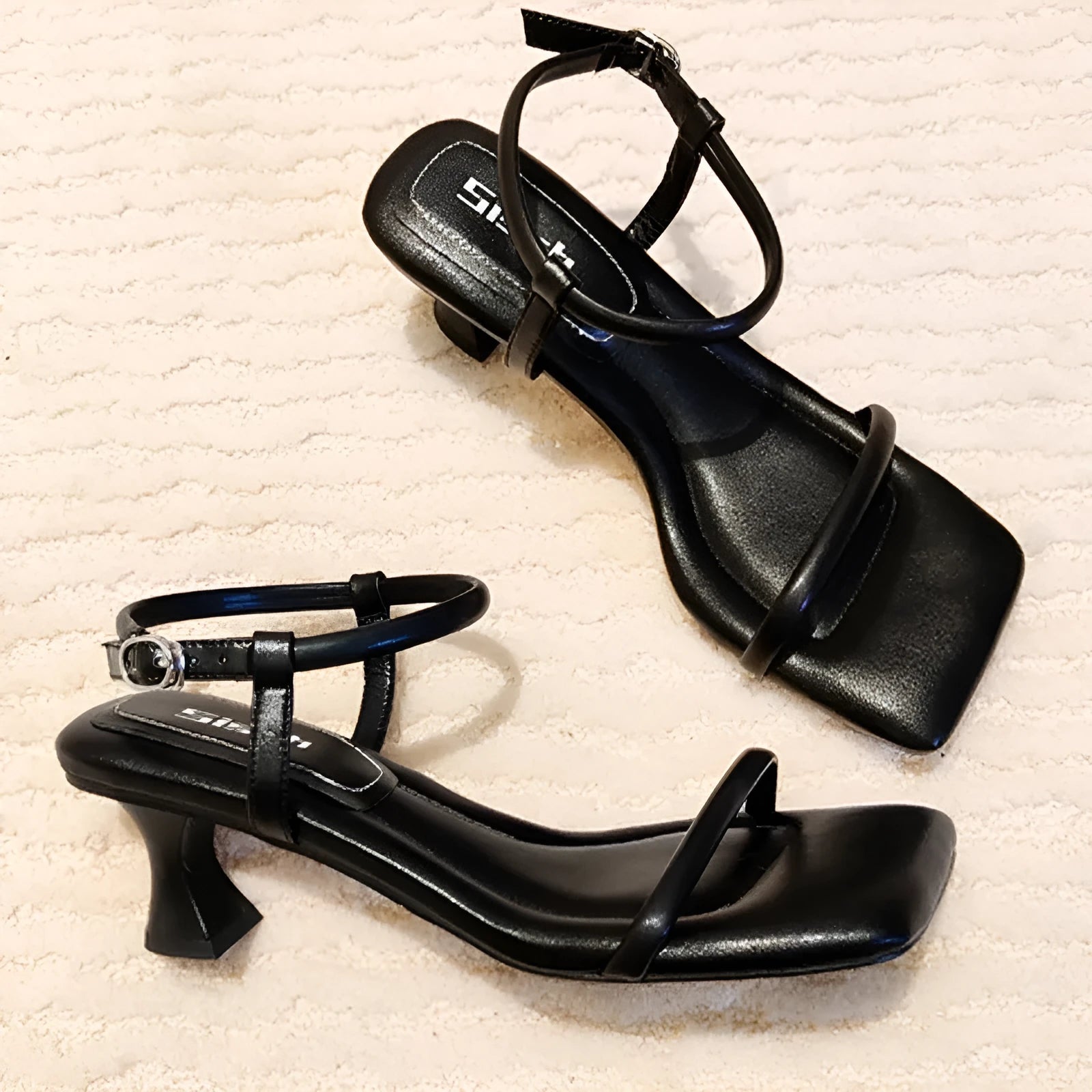 Black women's high heel sandals with a single buckle strap, square toe, and a chunky thick heel.