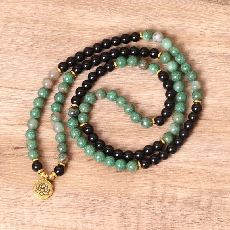 Green and black elastic beaded alloy bracelet on a wrist, showing its natural style and length.