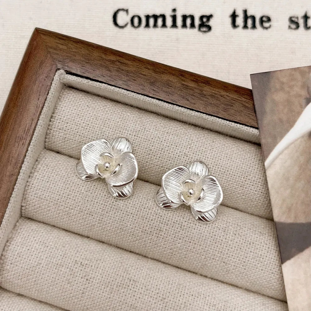 A pair of retro-style flower earrings with petal design, shown in gold electroplated finish.