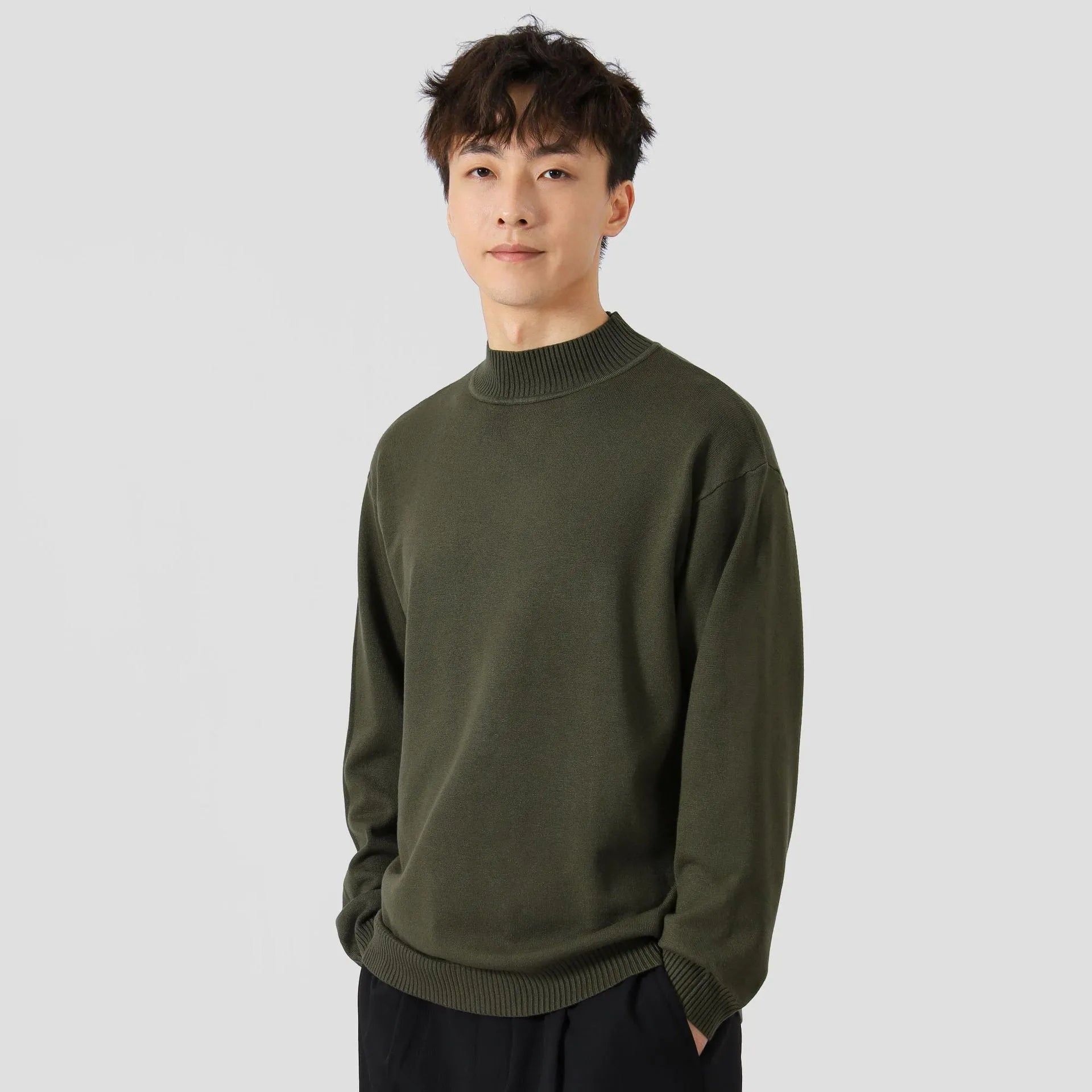 A man's loose-fitting, long-sleeve pullover sweater in a solid colour, showing a casual relaxed fit.