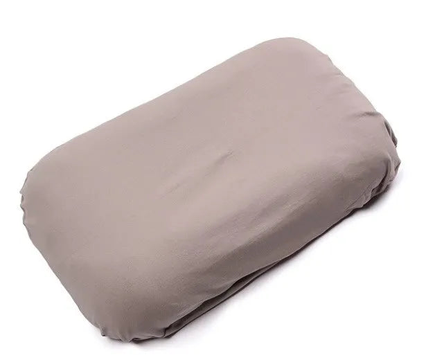 Cotton portable baby nest crib for newborns, beige colour, shown on a bed.