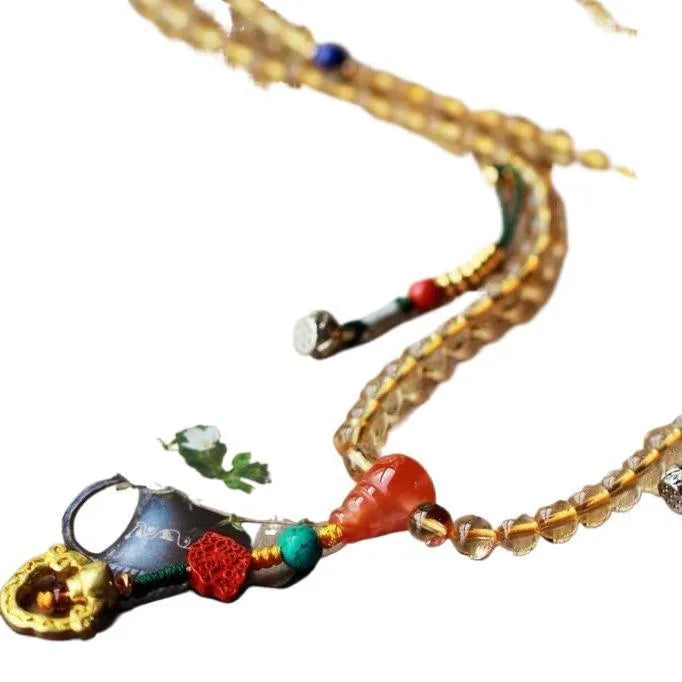 Yellow natural citrine bracelet with 1mm beads and filament accessory details on a wrist.