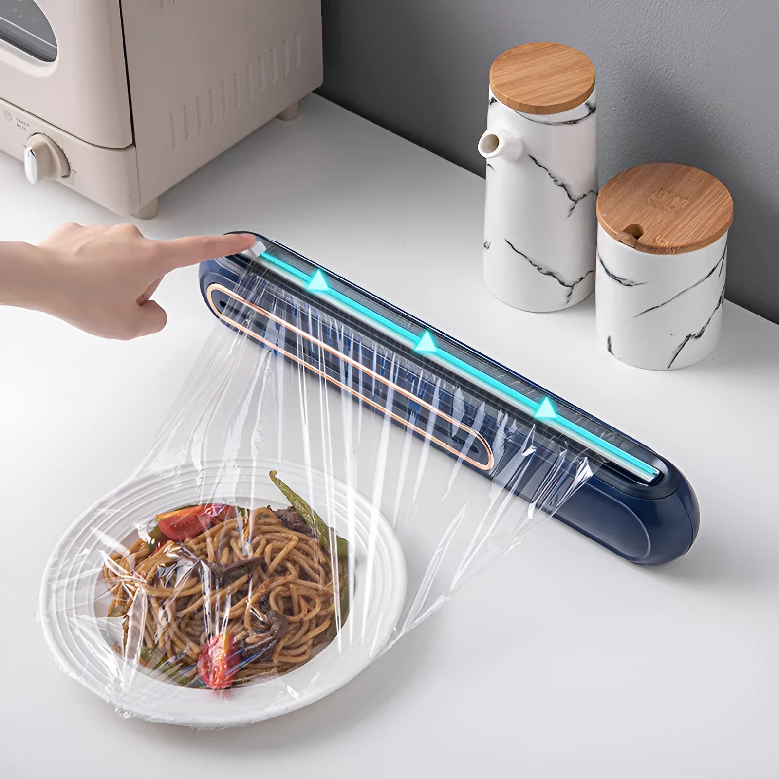 White and blue magnetic cling film cutter hanging on a fridge with a film roll