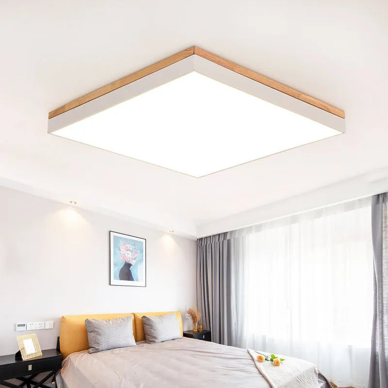 Round Scandinavian style wood and iron LED ceiling lamp with a white acrylic shade on a white ceiling.