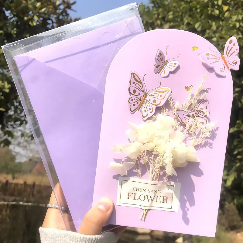 Handmade 3D butterfly-shaped greeting card with artificial flowers in a box, alongside its matching envelope.