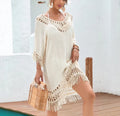 Apricot crocheted patchwork beach dress on a hanger showing textured knit and mid-length skirt.