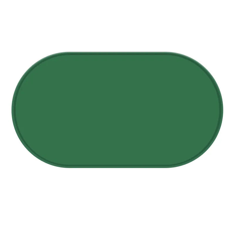 Green silicone cat feeding placemat on a floor next to a food bowl.