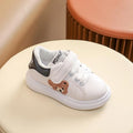 Children's black cartoon bear casual sports shoes with artificial leather upper and rubber sole.