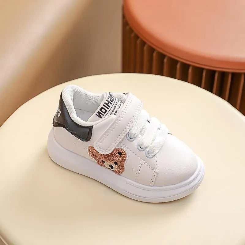 Children's black cartoon bear casual sports shoes with artificial leather upper and rubber sole.