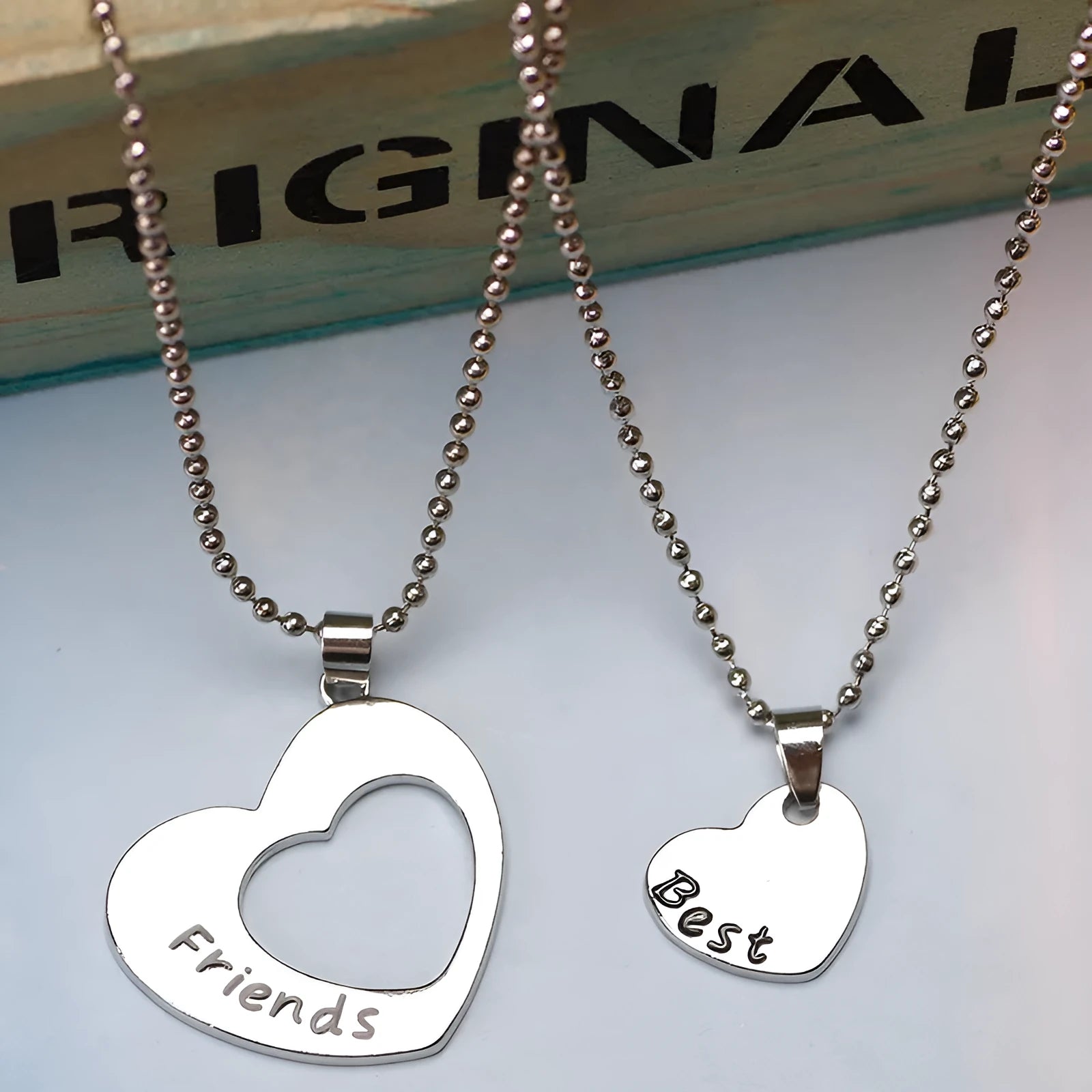 Two silver alloy heart-shaped puzzle necklaces on cross chains, matching set