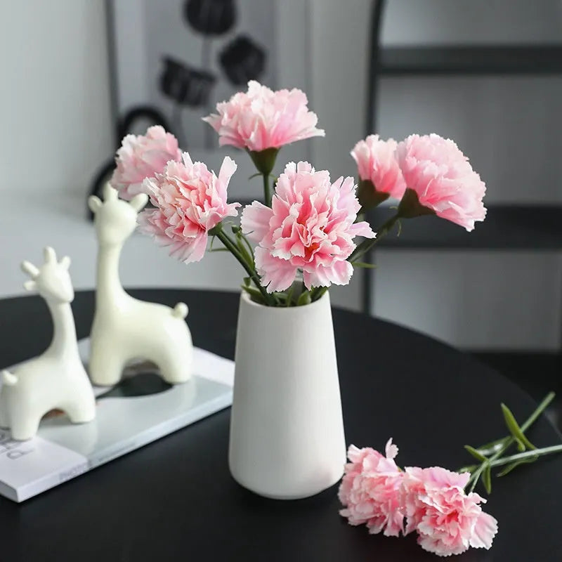 Single artificial mini carnation fake flower in soft rubber and silk material on white background