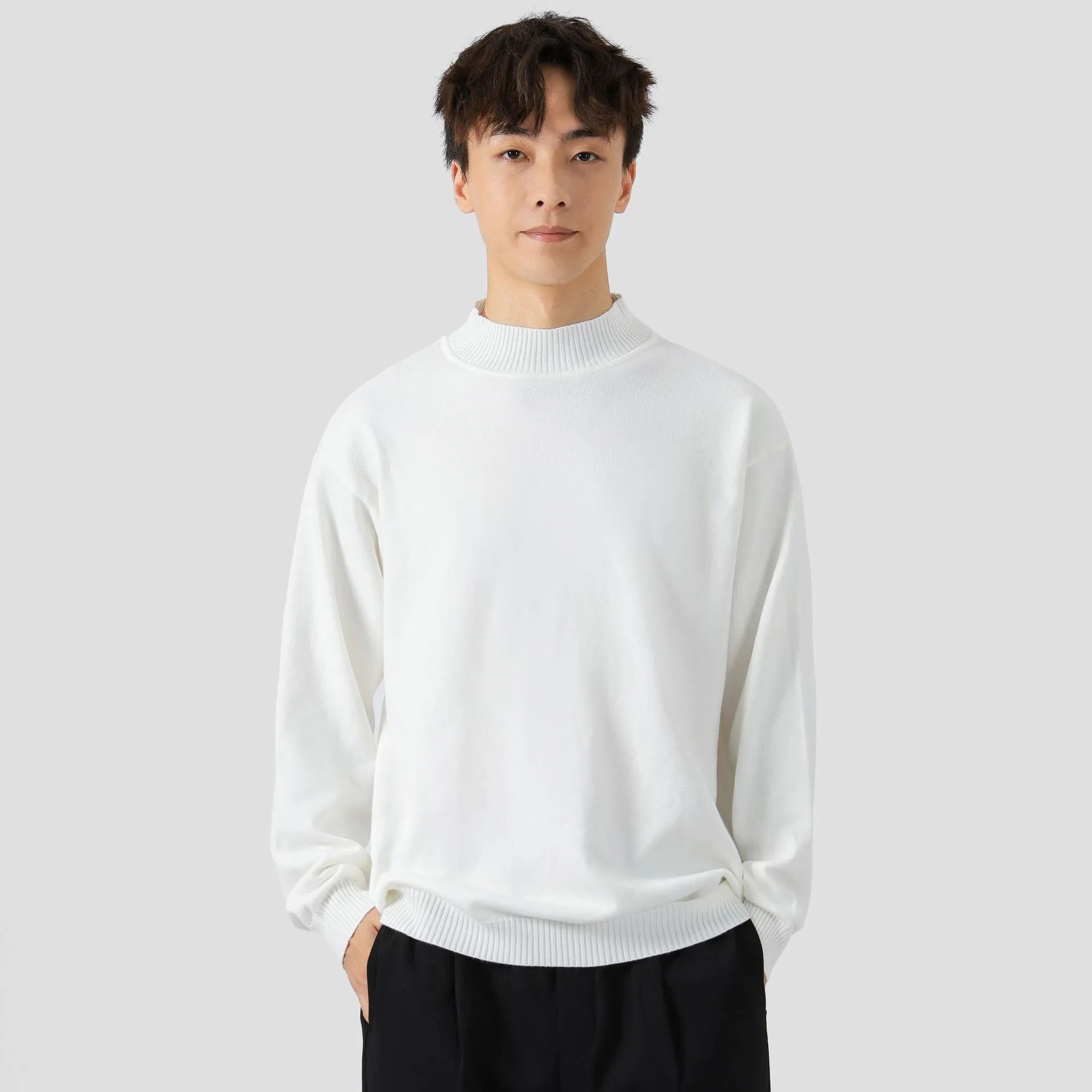 A man's loose-fitting, long-sleeve pullover sweater in a solid colour, showing a casual relaxed fit.