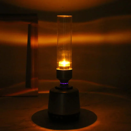 White silver candlelight Bluetooth speaker and night light on a table.