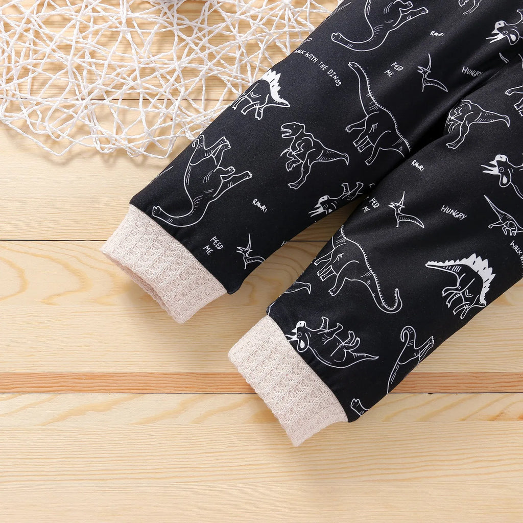 Cotton children's pants suit with dinosaur cartoon pattern in beige, pullover top and trousers set on child model
