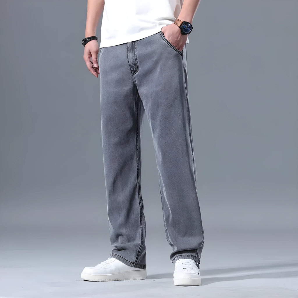 Man wearing light blue loose straight-leg lyocell jeans with a zipper fly.