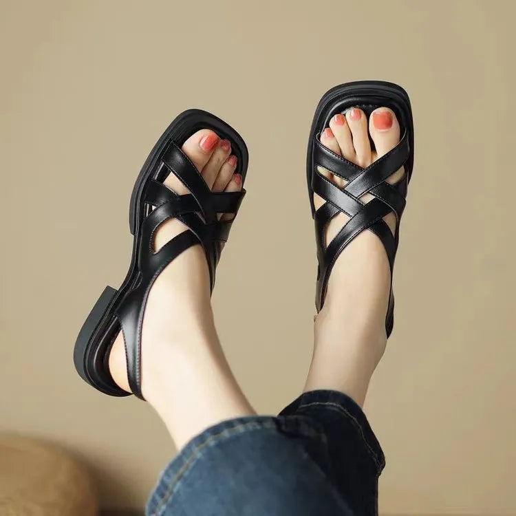 Women's glossy black patent leather beach sandals with a square toe and cross-belt design on a rubber sole.