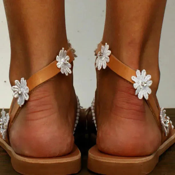 Brown women's floral Roman sandals with flat sole and slip-on design