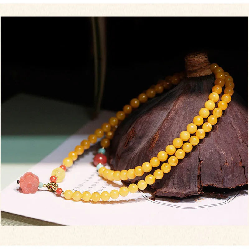 Yellow amber bracelet with 5mm round beads and animal zodiac design on a wrist.