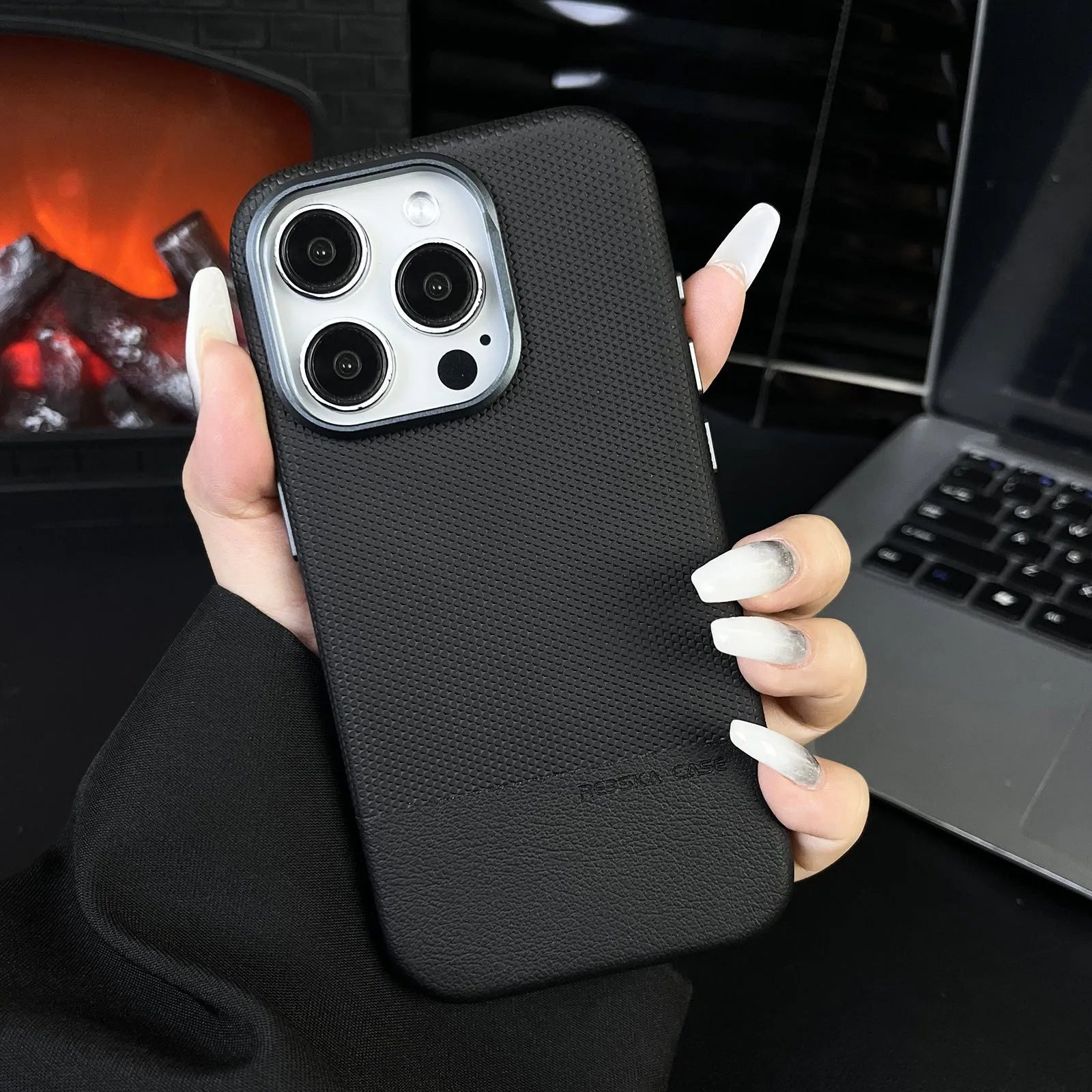 Black magnetic iPhone case with dragon scale texture and stitching, shown on an iPhone.