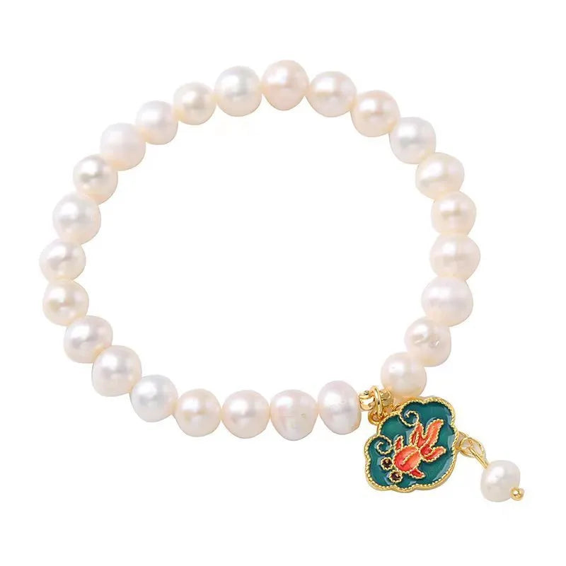 Natural freshwater pearl bracelet with vintage goldfish pendant and lotus motif on white background