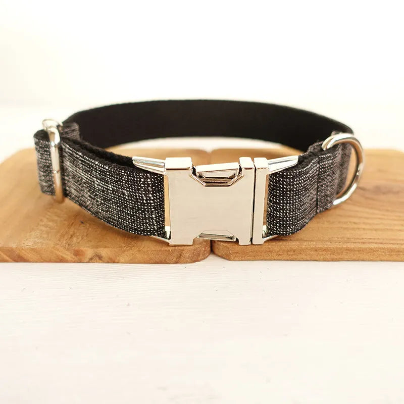 Black polyester padded dog collar with light gold trim and matching lead on a light surface