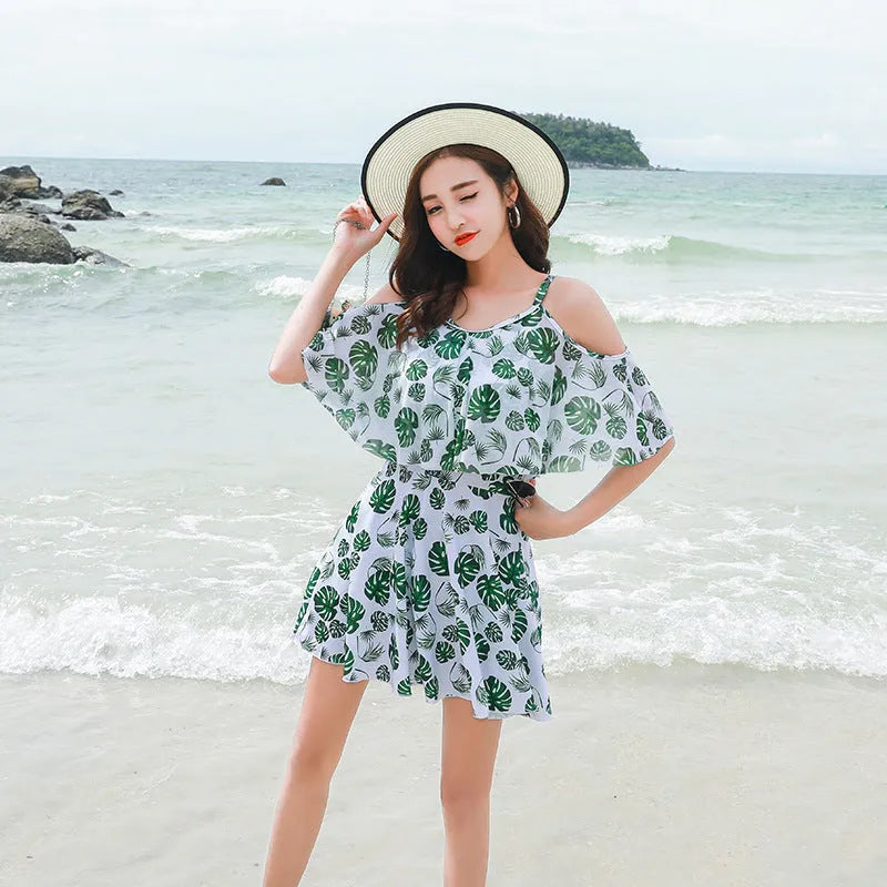 Women's green leaf style printed one-piece swimsuit laid flat.