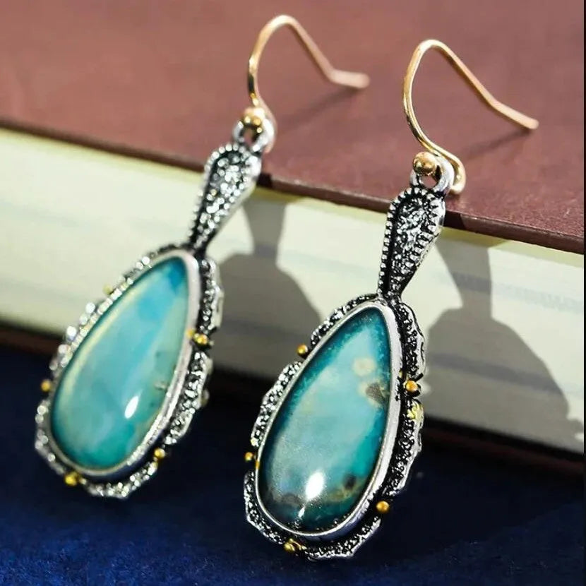 Antique silver turquoise teardrop petal drop earrings on a woman, alloy construction, vintage style
