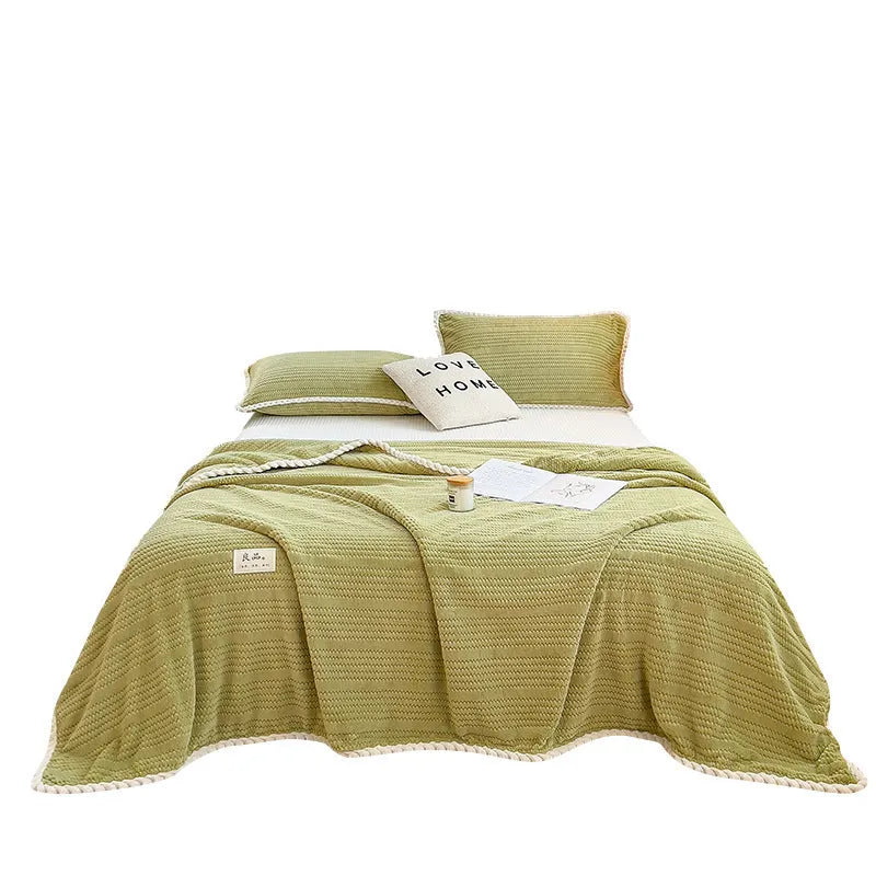 Solid colour jacquard milk velvet blanket in green on a bed with Nordic style decor