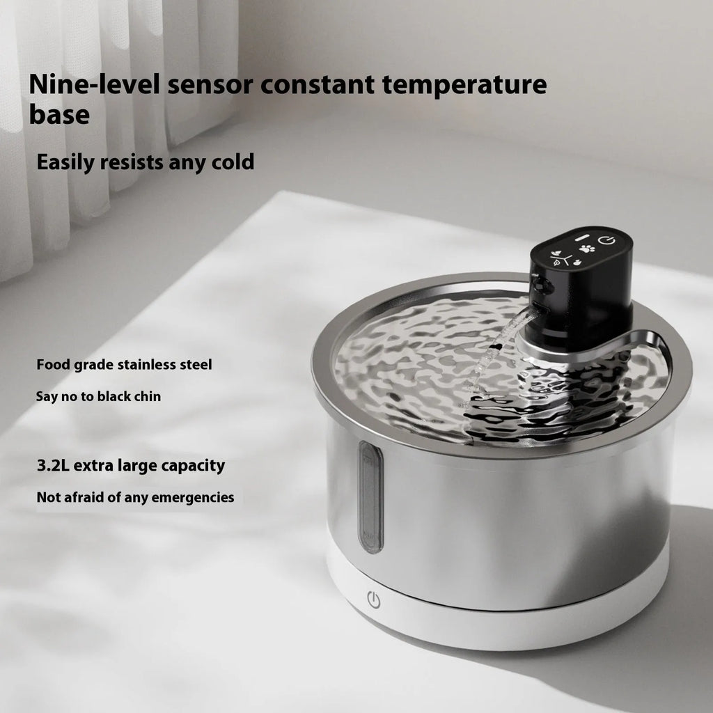 White stainless steel cat and dog water fountain with a constant temperature heating base on a table.