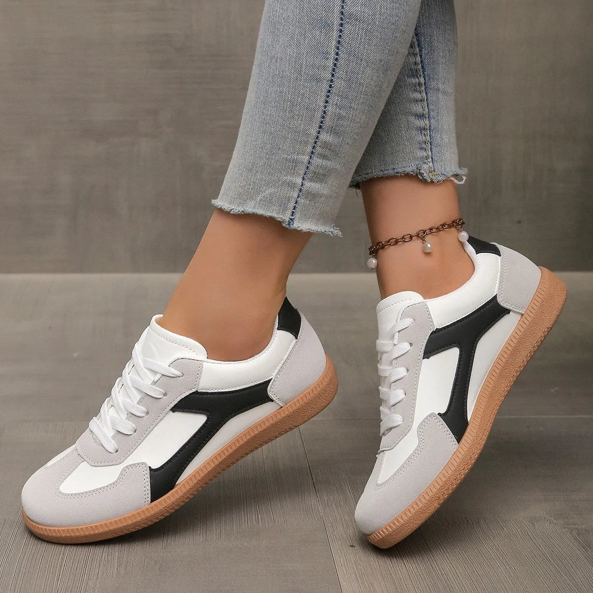 A pair of retro-style low-top lace-up sneakers in a selected colour on a plain background.