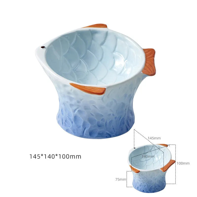 Set of four blue fish-shaped ceramic cat bowls with tilted, elevated design on a table.