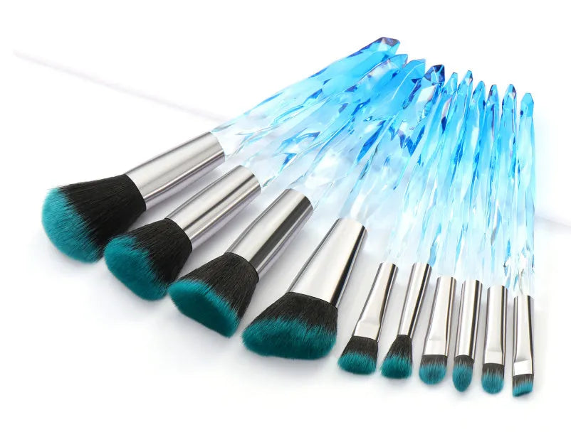 Ten crystal-handle foundation brushes with artificial fibre bristles in a set, showing black, blue, red, and yellow colour options.